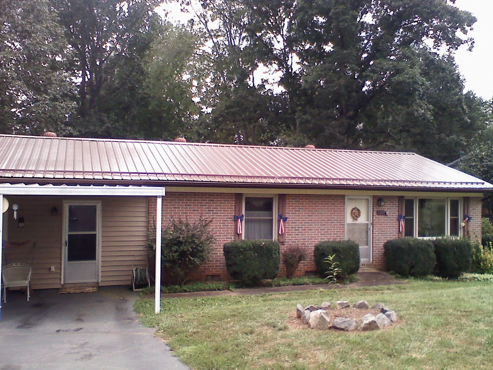Bronze metal roof and carport on a brick ranch home — Roof Repair work by our crew in Nashua